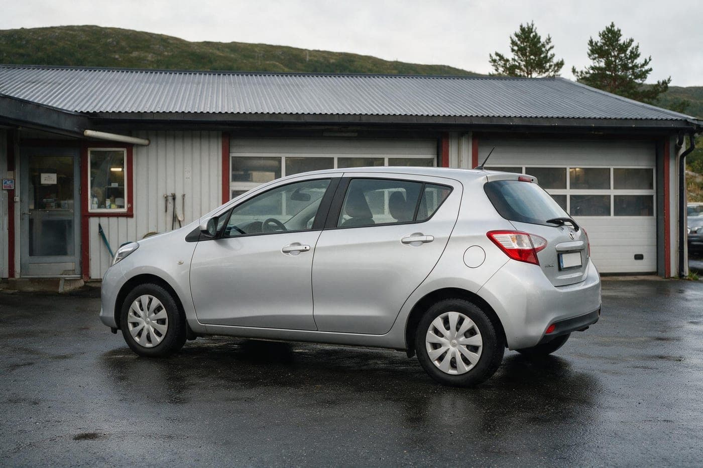 Sølvgrå leiebil parkert utenfor verkstedet på Skodjevegen